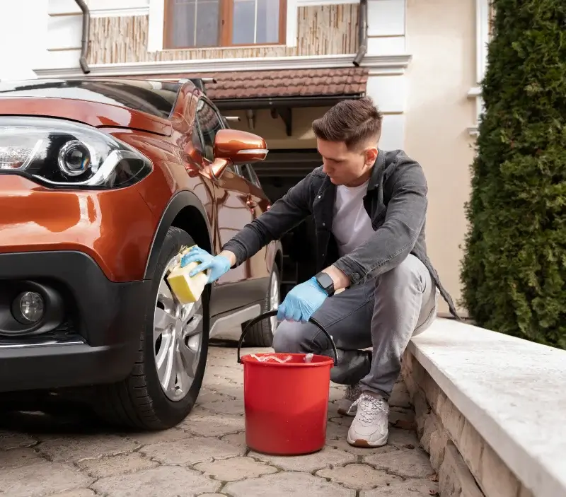 Lavage auto à domicile Le Breuil-en-Auge : professionnel intervenant sur un véhicule